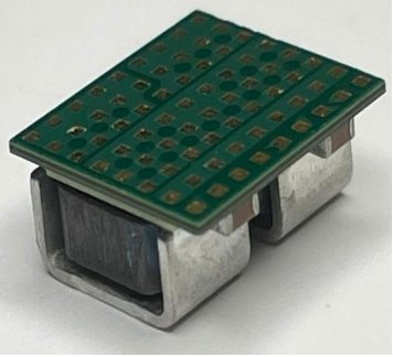 TDM22545DXUMA1 power stage module with the LGA pad array facing up and two metal-clad integrated inductors visible underneath