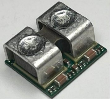 Close angled view of the two integrated inductors on the TDM22545DXUMA1, with decoupling components along the substrate edge