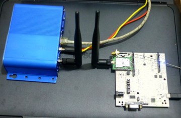 A MultiTech Conduit LoRaWAN gateway with two antennas beside a LoRa node board