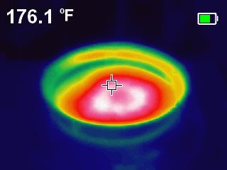 An infrared thermal image of a metal pan on an induction hob