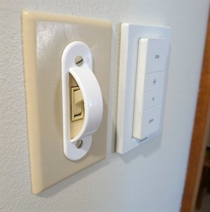 A Philips Hue Zigbee dimmer switch mounted beside a wall switch
