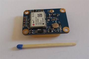 A u-blox NEO-M8N GNSS module on a breakout board with a matchstick for scale