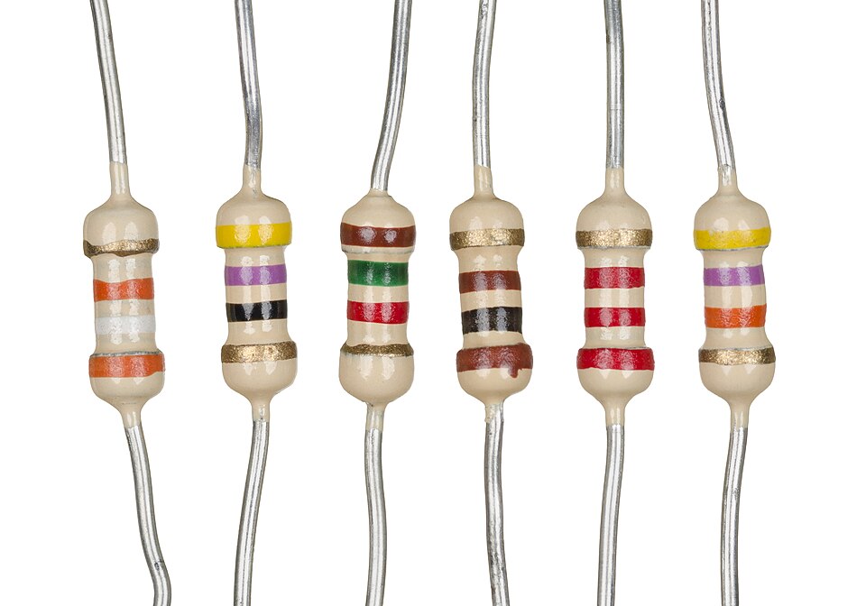 Six axial through-hole resistors with different colored value bands on a white background