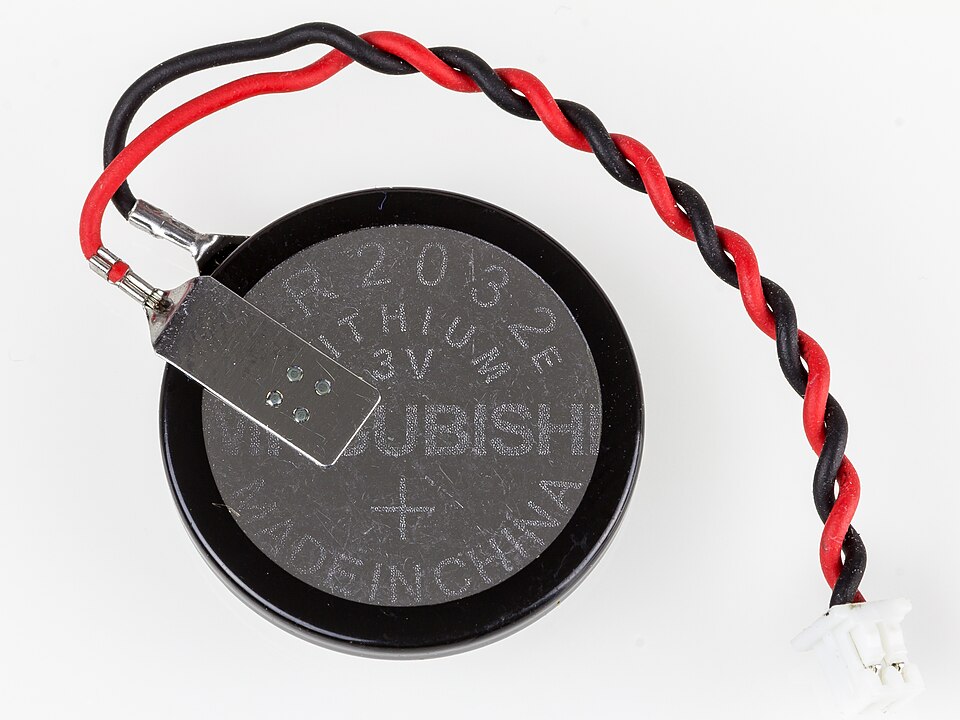 CR2032 lithium coin cell with a spot-welded tab, twisted red and black leads, and a small white connector
