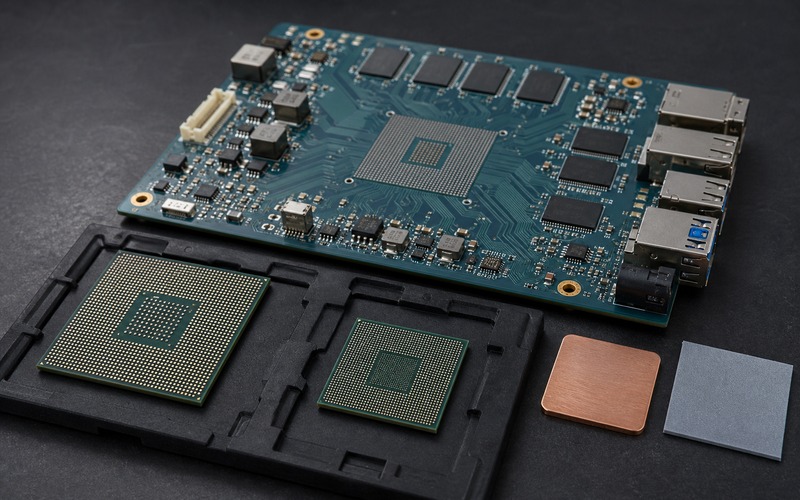 Two alternative BGA processors beside an edge AI validation PCB with an empty land pattern, memory, power stages and thermal interface parts