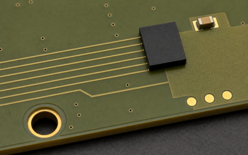 Olive ENIG layout coupon with one smooth-sided leadless QSPI flash, six controlled copper routes, one local ceramic capacitor and separated production test pads